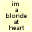 A static image with a light yellow background displays the text "im a blonde at heart" in black pixelated font, accompanied by small white heart symbols.