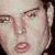 Pixelated close-up of a person's face showing eyes, nose, and mouth with soft skin tones and dark hair on the right side.