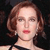 Pixelated close-up of a person with light brown wavy hair, red lips, and a black strap visible on the shoulder.