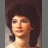 Two side-by-side pixelated portraits of a person with dark curly hair, one showing a neutral expression and the other a smiling expression.