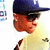Pixelated profile view of a person wearing dark blue cap and light yellow shirt, with visible ear and facial features.
