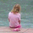 A static image of a pixelated girl in pink clothing kneeling by water with overlaid text about feeling rain on skin.