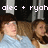 Two people with brown hair lie side-by-side on a light blue surface under dark background pillars, with pixelated text above reading 'alec + ryoh' in white.