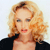 Pixelated image of a person with light brown curly hair, wearing a black top against a light background.