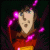 Animated sequence of a character with brown hair and blue eyes in red clothing, surrounded by pink glowing particles against dark background.