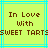 Pixelated text on a yellow background with cyan lines, showing "In Love With SWEET TARTS" in brown block letters
