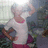 Pixelated figure in white top and red bottom, arms raised, against blurred background with green and blue tones.