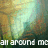 Pixelated image with abstract light and color gradients, featuring a bright central glow surrounded by muted earthy tones and greenish hues, with white text at the bottom reading 'all around me' in block letters.