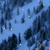 Pixelated blue-toned image with scattered dark shapes and small white specks against a light blue background.