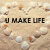 A static image shows a sandy beach with pebbles forming the phrase "U MAKE LIFE" above and "7/01/08 - 3:33" below, while an animated overlay displays a heart-shaped golden object held by hands with red text reading "worth living.".