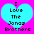Two identical cyan hearts on bright pink background with black pixelated text reading "I Love The Jonas Brothers" inside each heart.