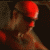 A person with a red head covering and dark sunglasses appears in a sequence of showing slight head movement against a dark background