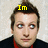 A pixelated image of a person with brown hair and blue eyes, wearing a dark jacket over a red shirt, with yellow text above the head.