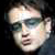 Pixelated static image of a person's face with visible facial features and partial hair, rendered in low resolution on a dark background.
