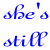 Blue cursive text "she's still" appears left, black diagonal text "MINEOCCUPIED" in middle, red text "WITH" right, with alternating green and purple "1985" repeated in two below