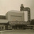 Static pixelated image of a train engine on tracks with a light background, showing a locomotive with a smokestack and visible wheels.