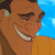Pixelated close-up of a smiling character with brown skin, dark hair, and a light brown shirt against a blue background.
