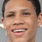 Pixelated close-up of a person's face showing eyes, nose, mouth with visible teeth and ear against light gray background.