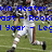 Pixelated image of a person in white athletic gear running on a grassy field with blue text overlay.