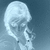Pixelated grayscale image of a human skull with closed eyes against a gradient blue background.