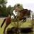 Pixelated static image of a person riding a horse in an outdoor setting with greenery and light sky.