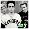 Black-and-white photo of four people in a , one wearing 'LUGGER' shirt with green 'GREEN day' text overlay
