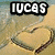 Beach scene with heart drawn in sand, water washing over it; text "LUCAS" appears at top left.