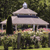 Pixelated image of a light-colored gazebo with a domed roof and dark trim, set against a blurred green background with hints of pink and yellow foliage.