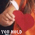 showing hands holding a red heart against an orange background with changing text
