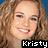 Pixelated close-up of a person with curly light brown hair, smiling face, and visible teeth against blue background.