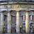 Static pixelated image of a building facade with columns and decorative architectural details under a bright light source.