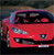 Red vehicle with visible headlights and grille, dark interior, and blurred background in pixelated style.