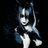 Animated icon of a character with blue hair and black outfit, making hand gestures against dark background.