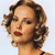 Pixelated close-up of a person with short brown hair styled in waves, red lips, and a light blue background.
