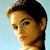 Pixelated close-up of a person's face in profile view against a light blue background, showing dark hair and warm skin tones.