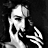 Pixelated grayscale image of a skeletal figure with an open mouth and outstretched hand against a dark background.