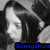 Pixelated grayscale image of a person with long dark hair, partially obscured by a dark shape, with blue text at the bottom.