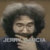 Pixelated static image of a person with dark curly hair and a light-colored shirt against a brown background.