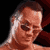 Pixelated static image of a person's face with brown hair and light skin tone against dark background, rendered in low-resolution 256x256 pixels.