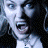 Pixelated image of a woman with dark hair and light skin, mouth open in an expression, wearing a white top against a black background.