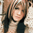 four elements: a photo of a woman with layered brown hair and a beige turtleneck sweater, and three large cream-colored letters R O X on white background