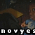 Pixelated static image shows a person in dark clothing holding a brown object against a dark background with partial text at the bottom.