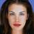 Pixelated close-up of a person with long dark hair, blue eyes, and red lips against a solid blue background.