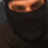 A pixelated close-up of a person's face showing eyes and part of the nose against a dark background.
