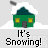 Green house with snow-covered roof and yellow windows, emitting smoke, with 'It's Snowing!' text below and 'badassbuddy.com' text above on gray background.