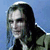 Pixelated image of a person with long dark hair wearing a dark jacket over a light shirt against a blue background.
