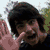 Six- of pixelated images showing a person with dark hair in various poses and expressions, including waving, singing into a microphone, and wearing blue hair