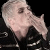 Pixelated cartoon character with light skin and gray hair in black clothing, two side-by-side frames showing slight head movement against a solid black background.