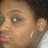 Close-up of a person's face with light brown skin tone, visible eye with white reflection, and pink lips against dark hair background.