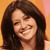 A static pixelated image shows a person with long dark brown hair against a gradient background transitioning from orange to pink.